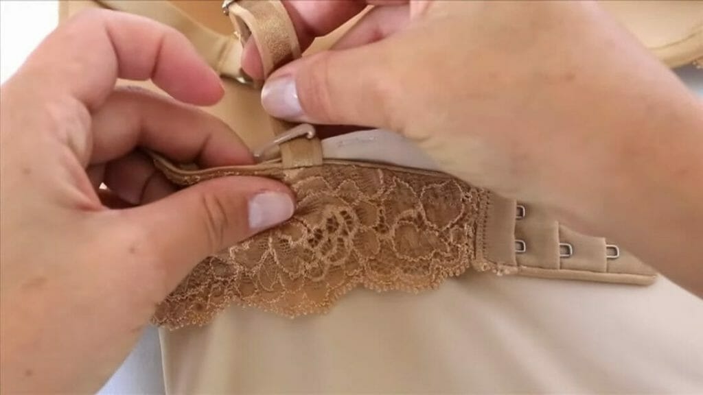 woman tucking shapewear under a bra