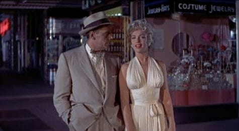 Marilyn Monroe in a white dress with a man beside