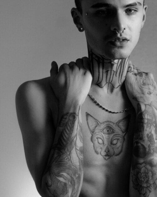 a black and white image of a man with a lot of tattoos on his upper body part