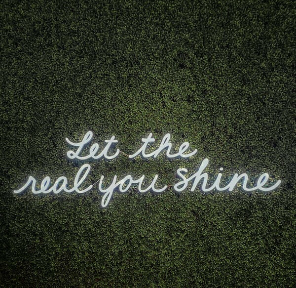 a neon sign that reads: Let the real you shine