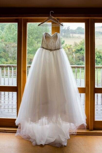 a wedding dress hang at the window