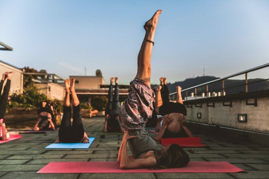 group of people doing shoulder stand during yoga session