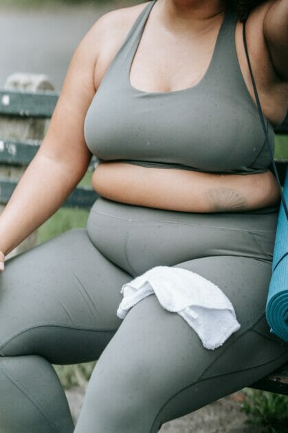 plus-size woman in gym outfit sitting down