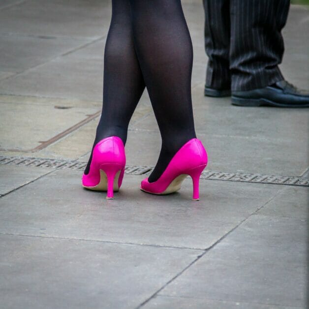 woman's feet wearing black stockings and pink heels