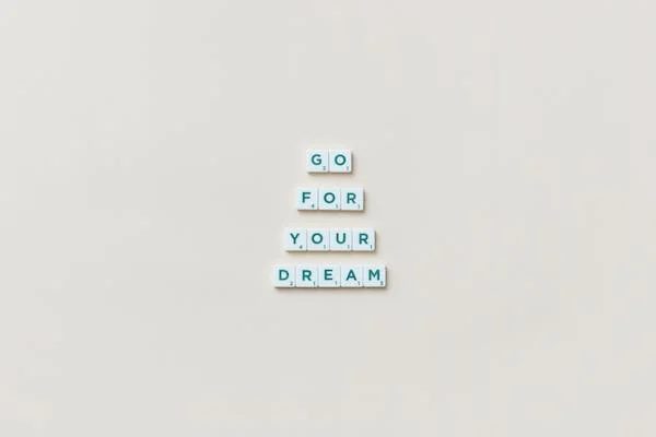 wood dice formed into a quote that says: "GO FOR YOUR DREAMS"