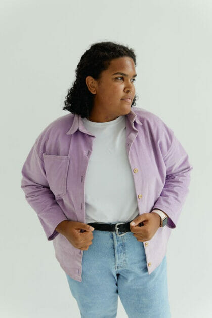 woman wearing jeans with belt and white shirt under a lavender shade polo jacket